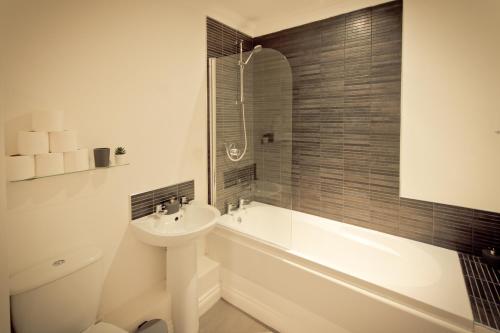 a bathroom with a sink and a tub and a toilet at Top View 2 Bedroom Apartments Plymouth in Plymouth