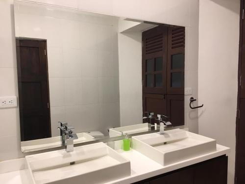baño con 2 lavabos y espejo grande en Casa de Balcones, en Garzón