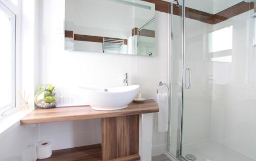 a bathroom with a sink and a glass shower at Tyndale B&B Torquay in Torquay