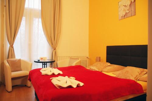 a bedroom with a red bed with towels on it at Penzion Alfa Poděbrady in Poděbrady