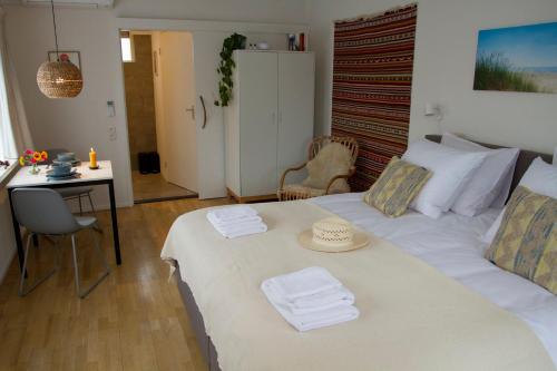 een slaapkamer met een wit bed met een hoed erop bij Studio Zonnehoek Schoorl in Schoorl
