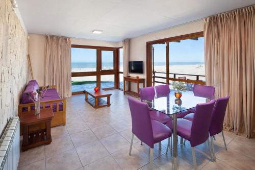 a dining room with a table and purple chairs at Altaplaya in Las Gaviotas
