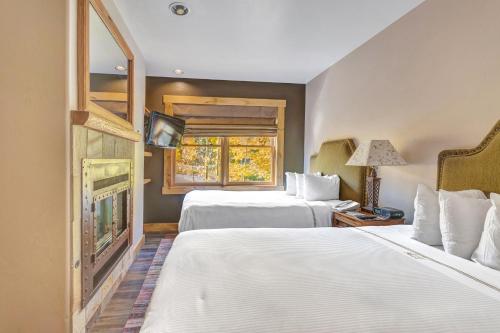 a hotel room with two beds and a television at Mountain Lodge Telluride in Telluride