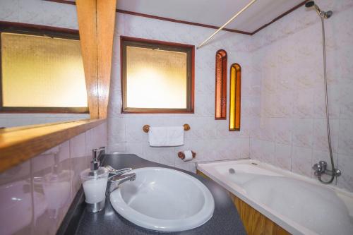 un baño con lavabo y bañera en Pao Pao Lodge Algarrobo, en Algarrobo
