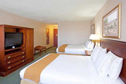 a hotel room with two beds and a flat screen tv at Holiday Inn Express and Suites Pittsburgh West Mifflin by IHG in West Mifflin