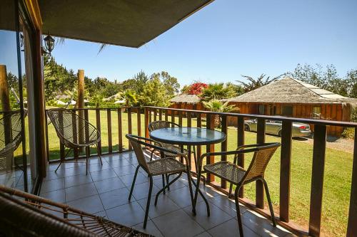 a patio with a table and chairs on a balcony at Pao Pao Lodge Algarrobo in Algarrobo