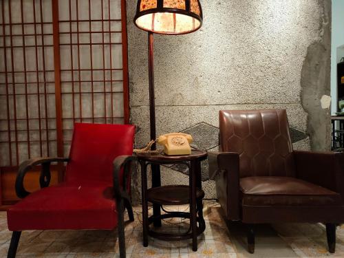 a chair and a table with a phone and a lamp at Old Mamaboy Marines Hostel獨立包棟三間雙人雅房 in Kaohsiung
