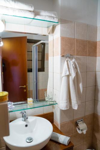 a bathroom with a sink and a mirror and towels at Yiannis Apartments in Ioannina