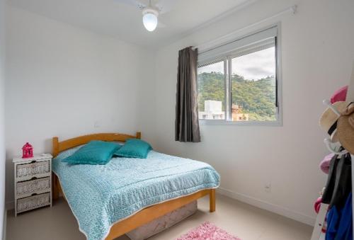 a bedroom with a bed and a window at Cobertura com Jacuzzi privativa in Governador Celso Ramos