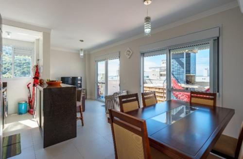 a kitchen and dining room with a table and chairs at Cobertura com Jacuzzi privativa in Governador Celso Ramos