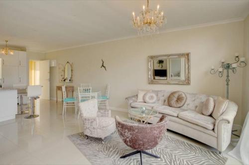 a living room with a couch and a table at L`Azur : Elegant Apartment with Sea View in Wilderness