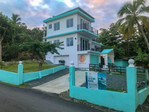 
a large white house with a blue roof at The Beach Pad in Rincon
