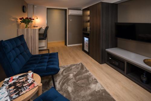 a living room with a blue couch and a tv at Guesthouse Centrum Hengelo in Hengelo