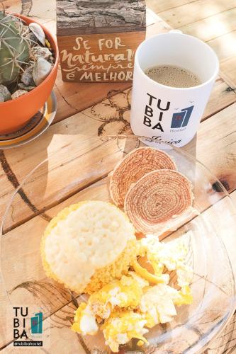 een glazen bord met een sandwich en een kop koffie bij Casa Cultural Tubiba Hostel in Tamandaré