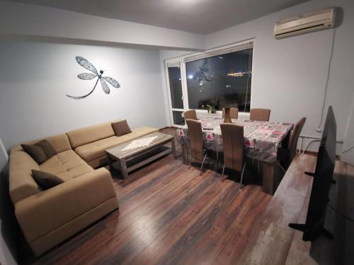 un salon avec un canapé et une table avec des chaises dans l'établissement Panorama Rooms, à Sofia