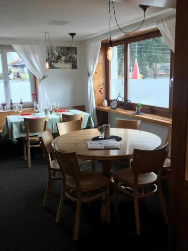 a dining room with a table and chairs and windows at L'ANGOLO DEI SAPORI in Rueun