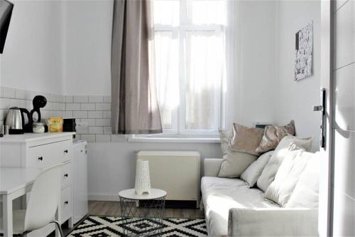 a living room with a white couch and a window at Corner 5 I Old Town I Cosy Studio in Krakow