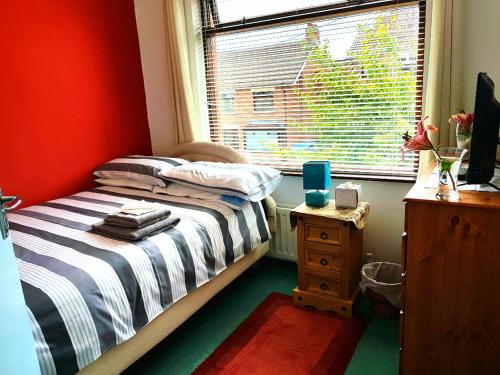 a small bedroom with a bed and a window at CEAD MILE FAILTE WEST BELFAST in Belfast