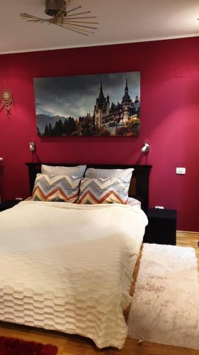a bedroom with a white bed with a red wall at GREEN VIEW in Sinaia