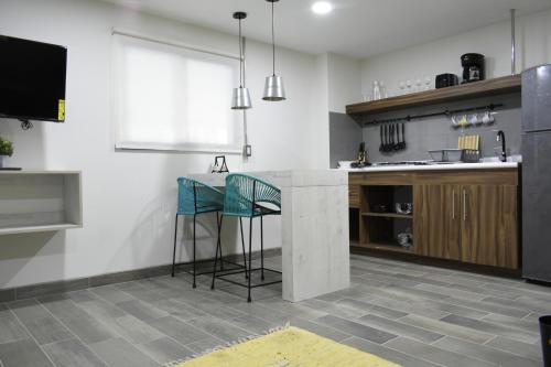 a kitchen with a counter and two stools at TJ Border Suites by Hosted by Me in Tijuana