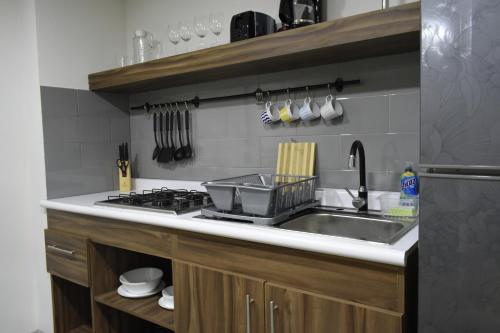a kitchen with a sink and a stove at TJ Border Suites by Hosted by Me in Tijuana