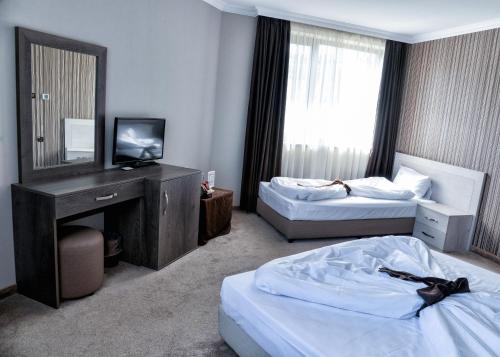 a hotel room with two beds and a television at Hotel Nove in Svishtov