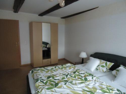 a bedroom with a bed with a green and white comforter at Pension an der Stadtmauer Apartments in Wernigerode
