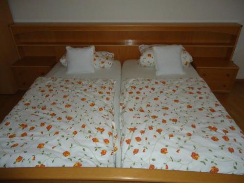 a bed with orange flowers on it at Pension an der Stadtmauer Apartments in Wernigerode