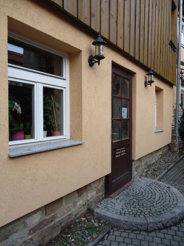 a building with a door and two windows at Pension an der Stadtmauer Apartments in Wernigerode