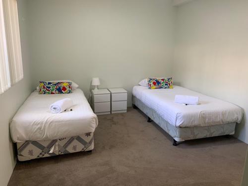 two beds in a room with white walls at Views on Spencer in Albany