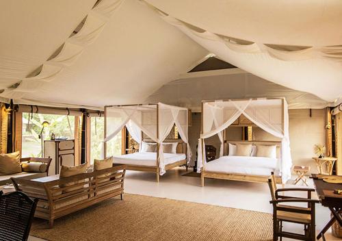 1 Schlafzimmer mit 2 Betten in einem Zelt in der Unterkunft The Beige in Siem Reap