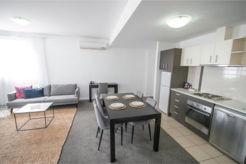 a kitchen and a living room with a table in a kitchen at Mantra Wollongong in Wollongong