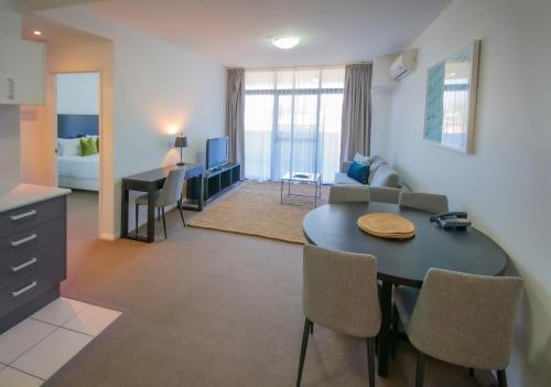 a kitchen and a living room with a table and chairs at Mantra Wollongong in Wollongong