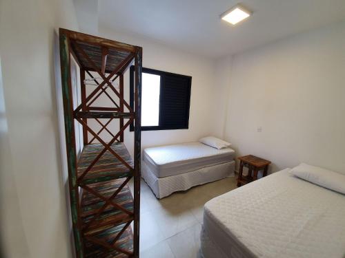 a bedroom with a ladder next to a bed at Flats Capitania Varam Pitangueiras in Guarujá