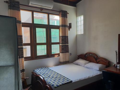 a small bedroom with a bed and a window at Trellis Homes in Colombo