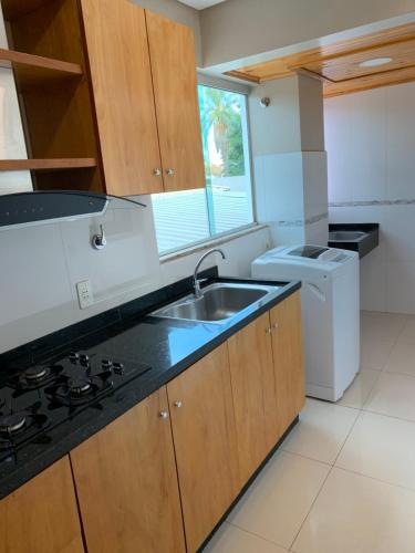 a kitchen with a sink and a washer and dryer at NatuCenter Hospedaje in Puerto Presidente Franco