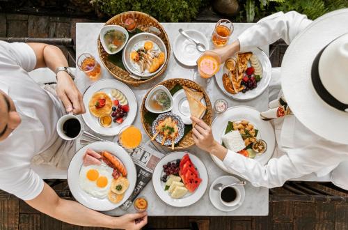 a group of people sitting at a table eating breakfast at 99 The Heritage Hotel in Chiang Mai