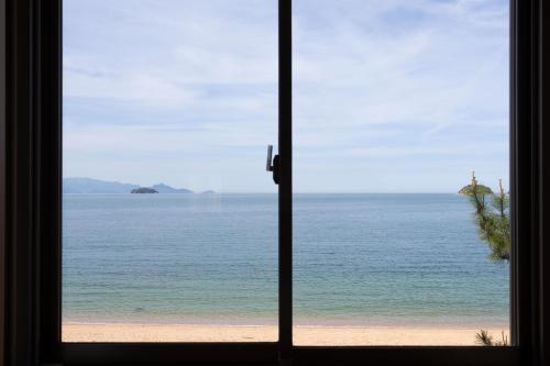 a view of the beach from a window at Jakomaru Park Tsuda in Sanuki