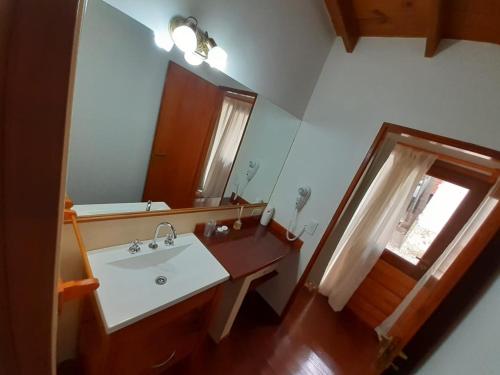 a bathroom with a sink and a mirror at Cabañas Paseo de las Luces in Mar de las Pampas
