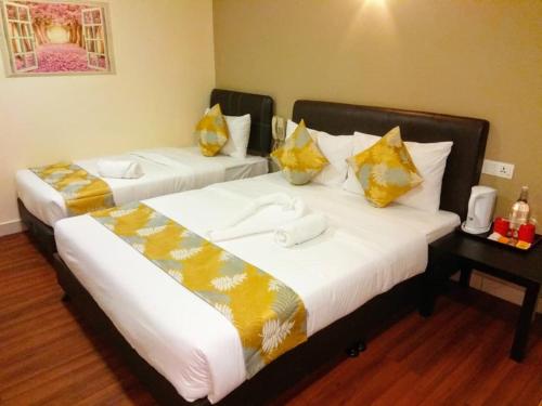 Hotel Sunjoy9 @ Mid Valley في كوالالمبور: سريرين في غرفة الفندق عليها مناشف