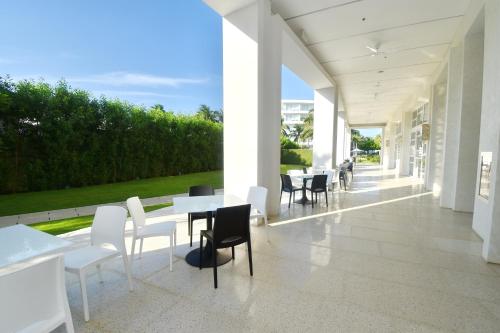 a dining room with white chairs and tables in a building at Aqua Boracay in Boracay