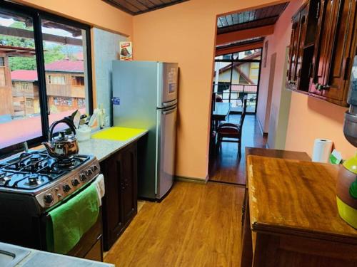 a kitchen with a stove and a refrigerator at Hostal La Casa De Rodrigo in Baeza