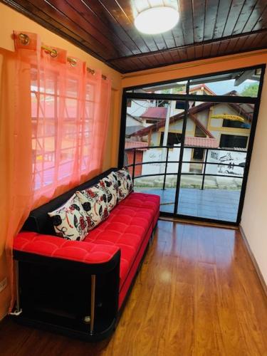 a red couch in a room with a large window at Hostal La Casa De Rodrigo in Baeza