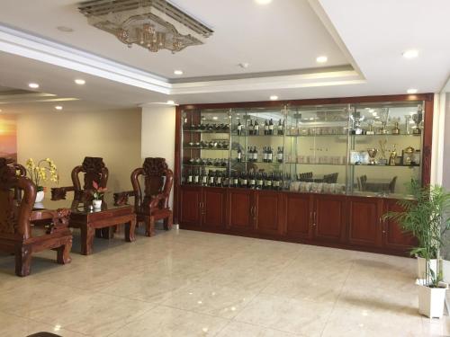Cette chambre comprend un bar avec des armoires et des chaises en bois. dans l'établissement Golf Star Hotel, à Hô-Chi-Minh-Ville
