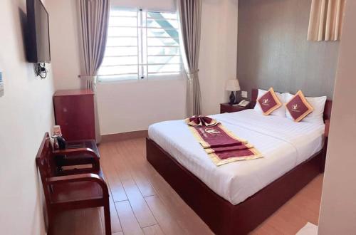 um quarto com uma cama grande e uma janela em Golf Star Hotel em Ho Chi Minh