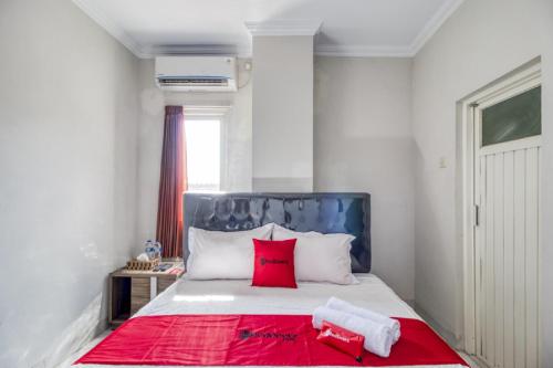 a bedroom with a large bed with red pillows at RedDoorz near Condongcatur Bus Station in Yogyakarta