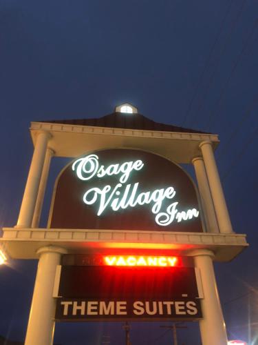 a sign for a cheese exchange store at night at Osage Village Inn in Osage Beach