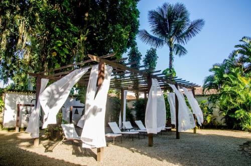a gazebo with white chairs and palm trees at Pousada da Marquesa in Paraty