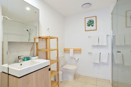 a bathroom with a sink and a toilet and a shower at Hope Street Apartments by CLLIX in Brisbane