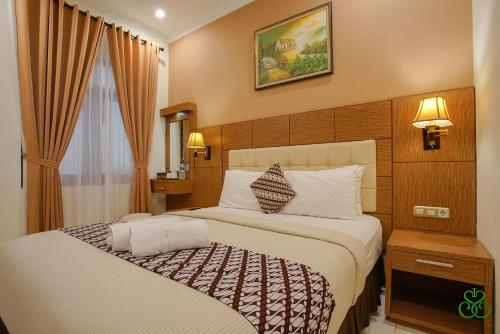 een slaapkamer met een groot bed in een hotelkamer bij Selaras Inn Syariah in Yogyakarta